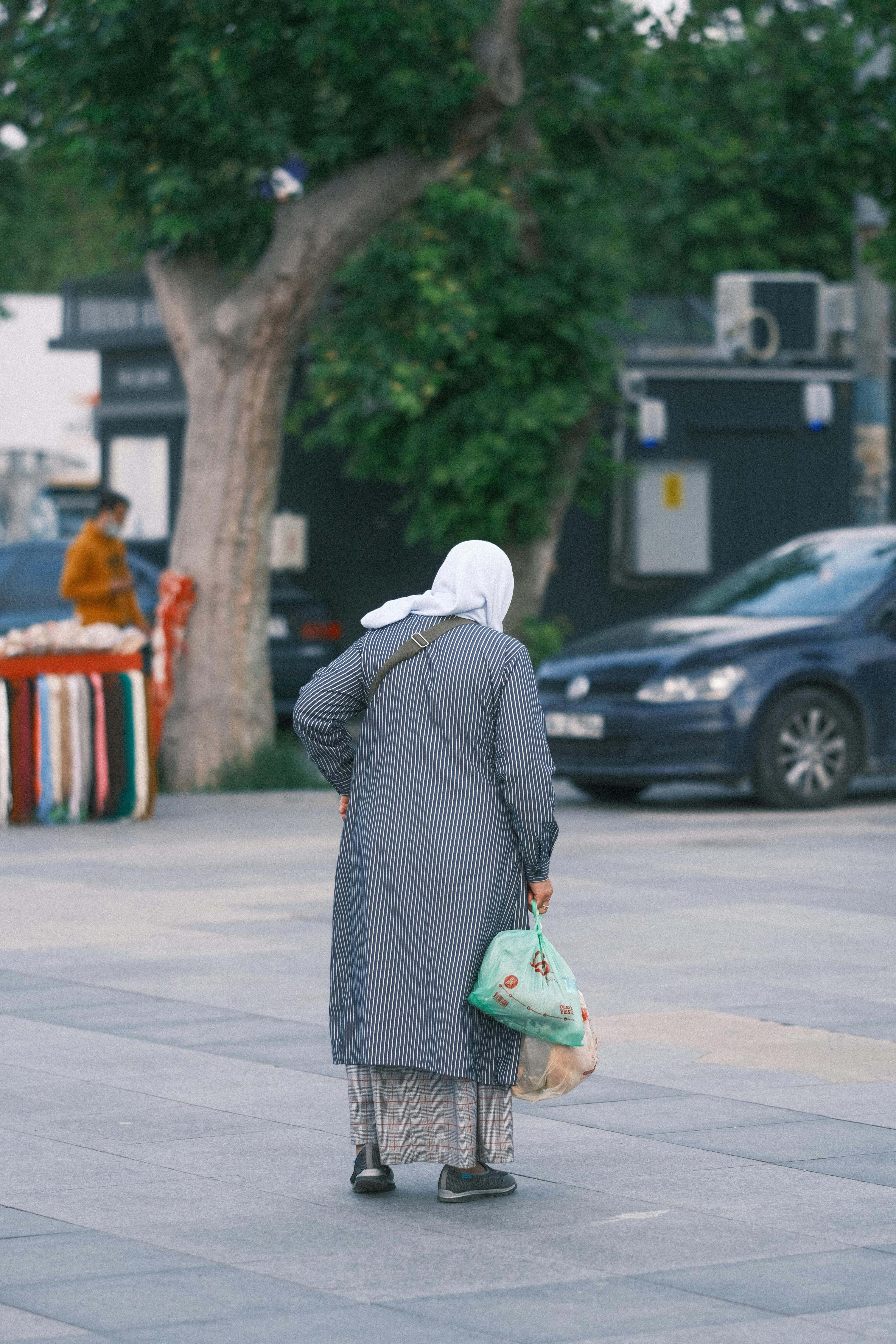 Woman in a Dress Carrying Plastic Bags · Free Stock Photo