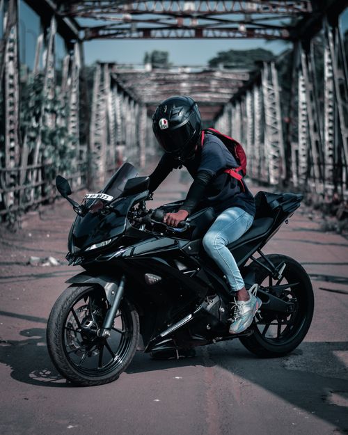 Free A motorcyclist in casual attire rides a sports bike on a steel bridge in Dharmadom, India. Stock Photo