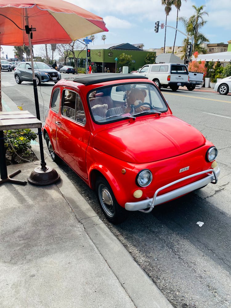 A Red Vintage Fiat 500 Parked On The Roadside