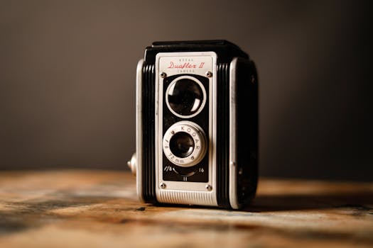 Close-up of a nostalgic Kodak Duaflex II camera on a rustic wooden table, embodying vintage charm.
