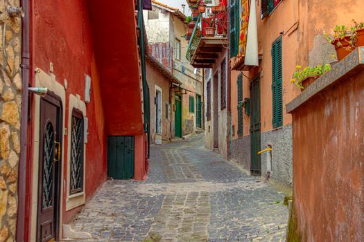 Explore a picturesque cobblestone alleyway in Italy with vibrant old world architecture.
