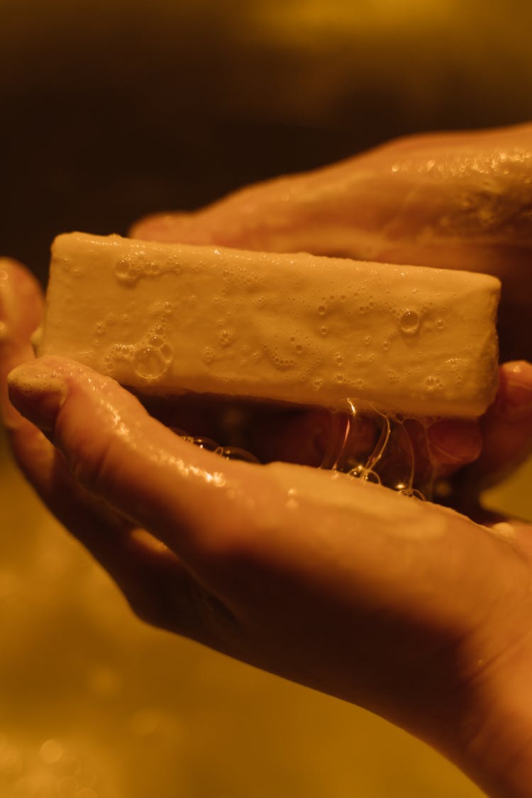 Person Holding A Wet White Bar Soap