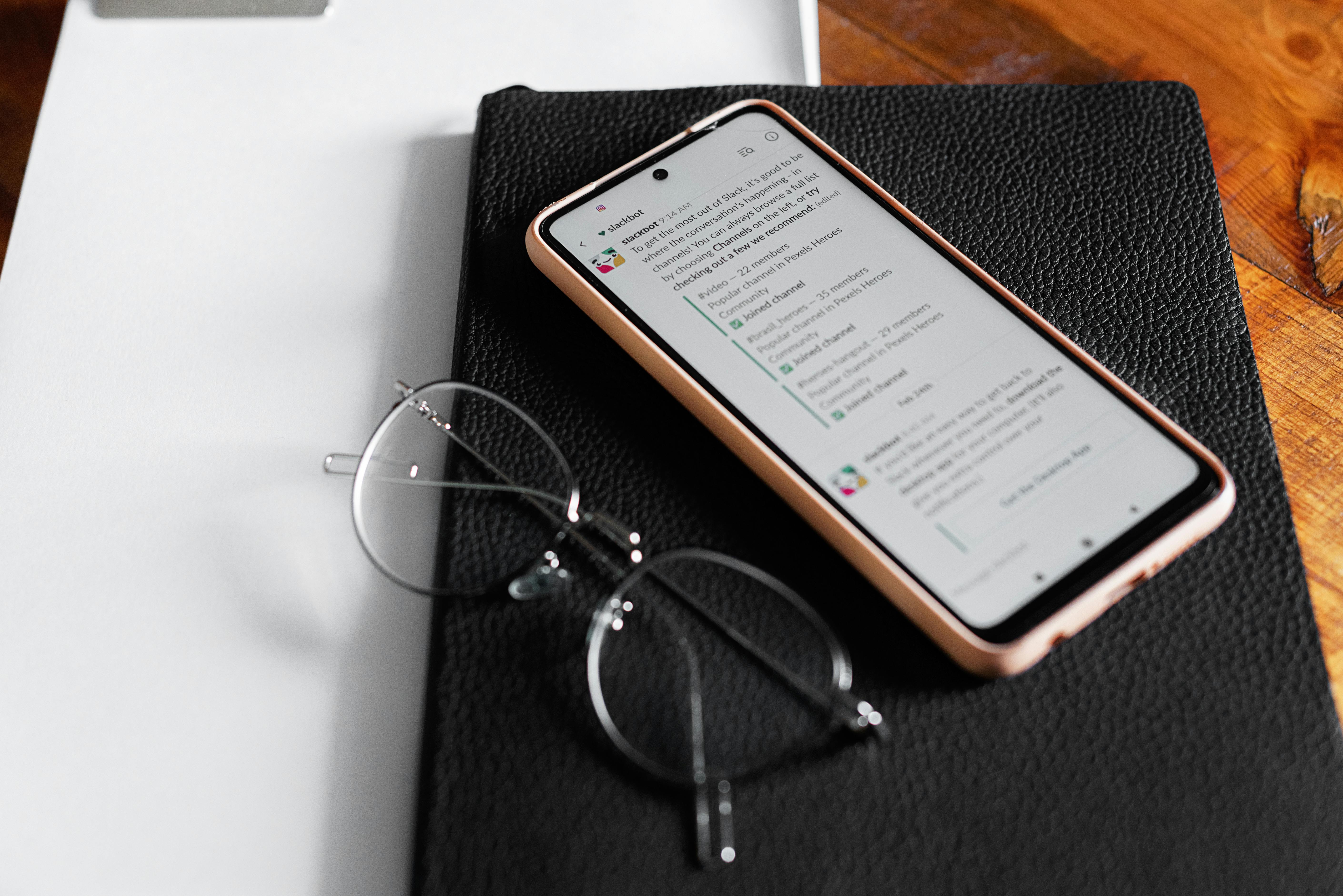 mobile phone and eyeglasses on top of a planner