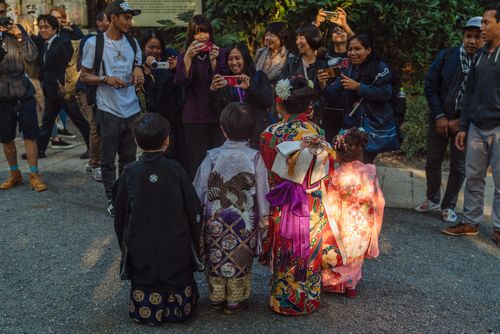 Free A vibrant gathering in Shibuya, Tokyo featuring children in traditional kimonos surrounded by tourists. Stock Photo