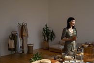 Woman in Gray and Black Shirt Standing Beside Brown Wooden Table