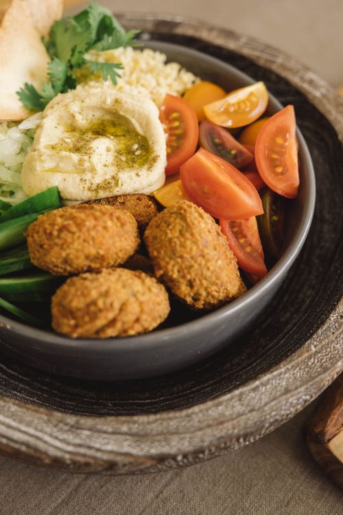 Free Close-up of a nutritious falafel bowl with hummus, tomatoes, and greens. Stock Photo