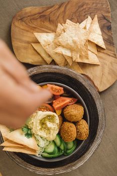 Delicious Mediterranean falafel bowl with fresh veggies and pita bread, top view.