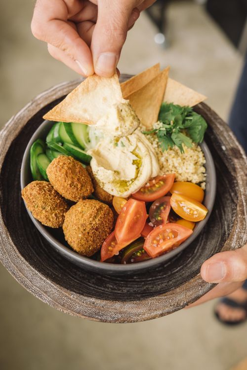 Free Delicious Mediterranean bowl with falafel, hummus, and fresh veggies. Stock Photo