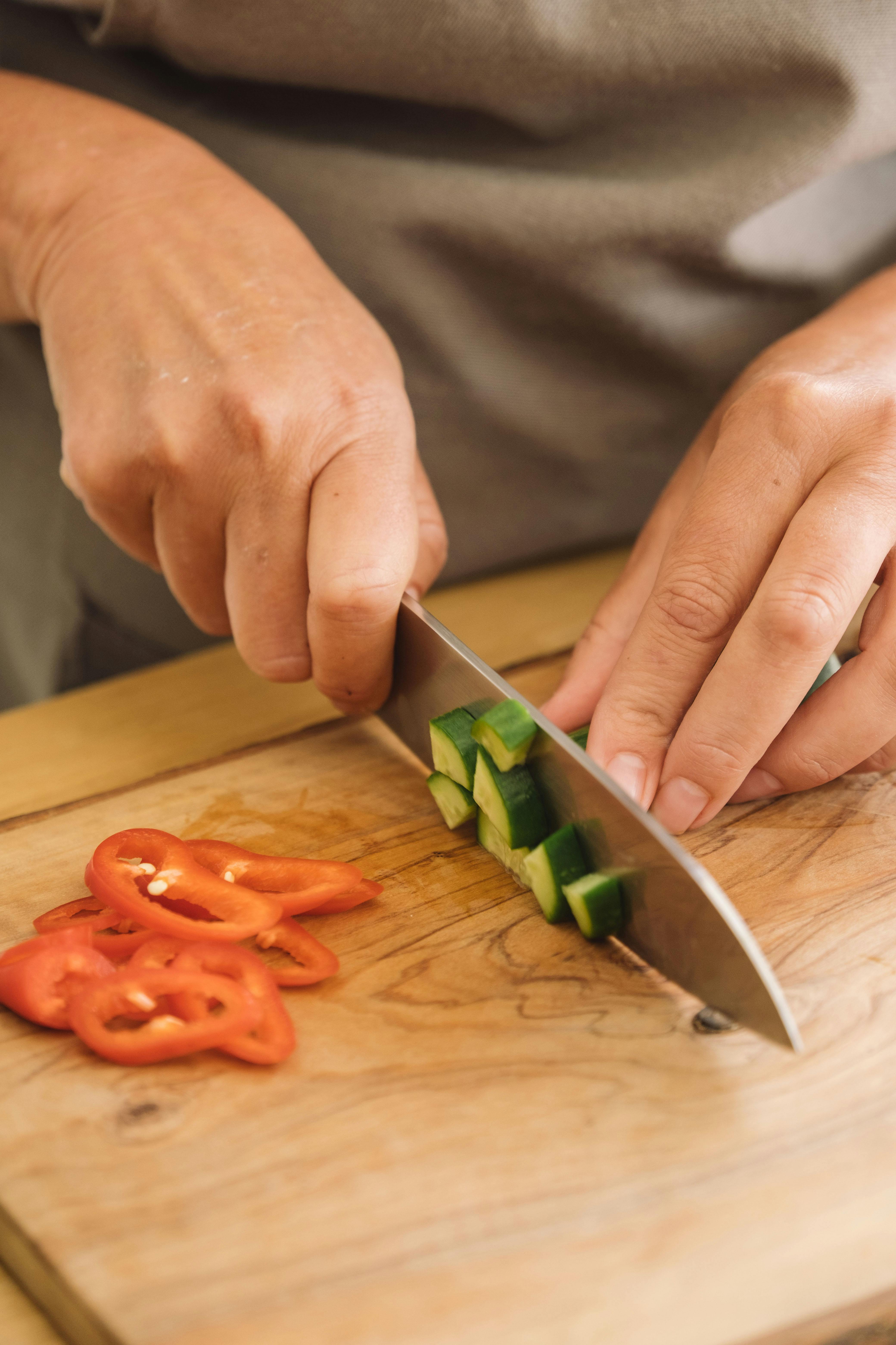 Close-Up Shot of a Knife and Sliced Vegetables on a Wooden Chopping Board ·  Free Stock Photo