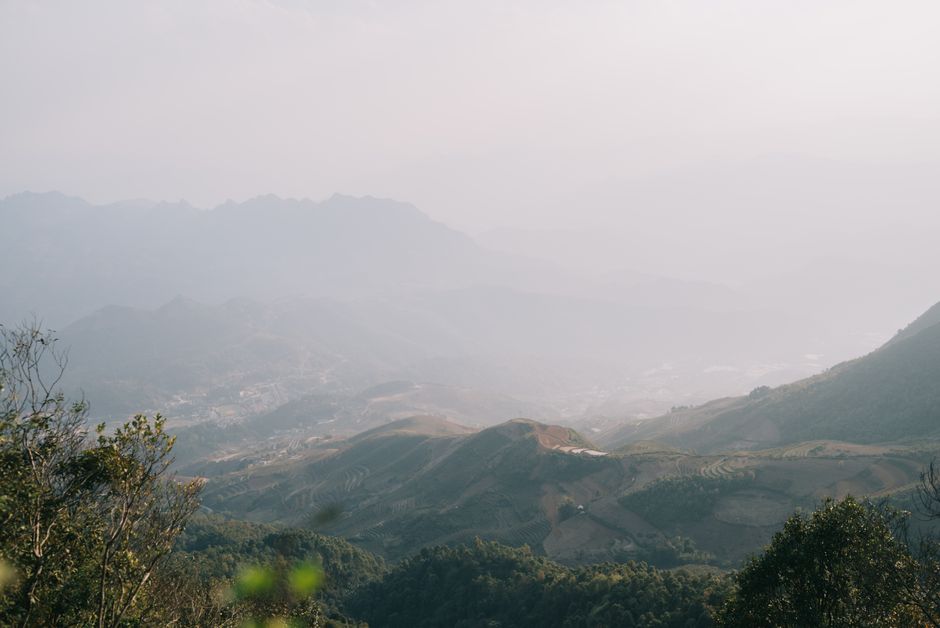Experience a tranquil mountain valley at dawn, enveloped in mist and fog, offering scenic views.