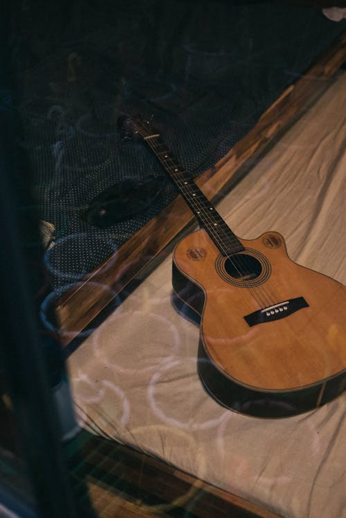 Kostnadsfri bild av akustisk gitarr, musikinstrument, säng