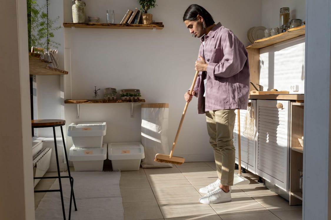 A person sweeping the kitchen floor