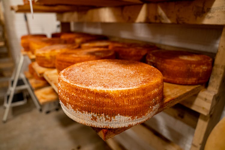 A Cheese Wheel On A Wooden Table Top