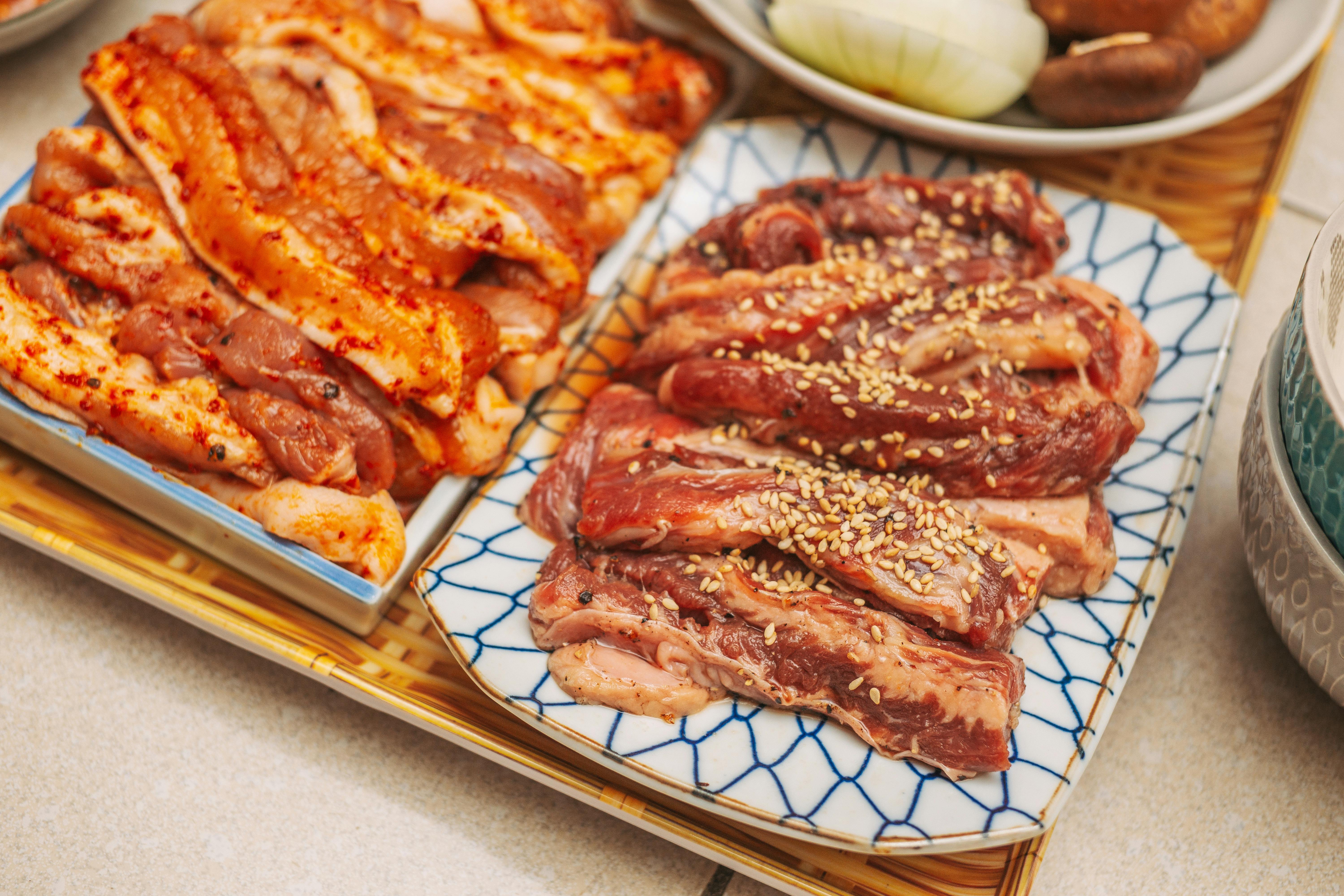 A selection of marinated meats with spices and sesame seeds, perfect for BBQ.