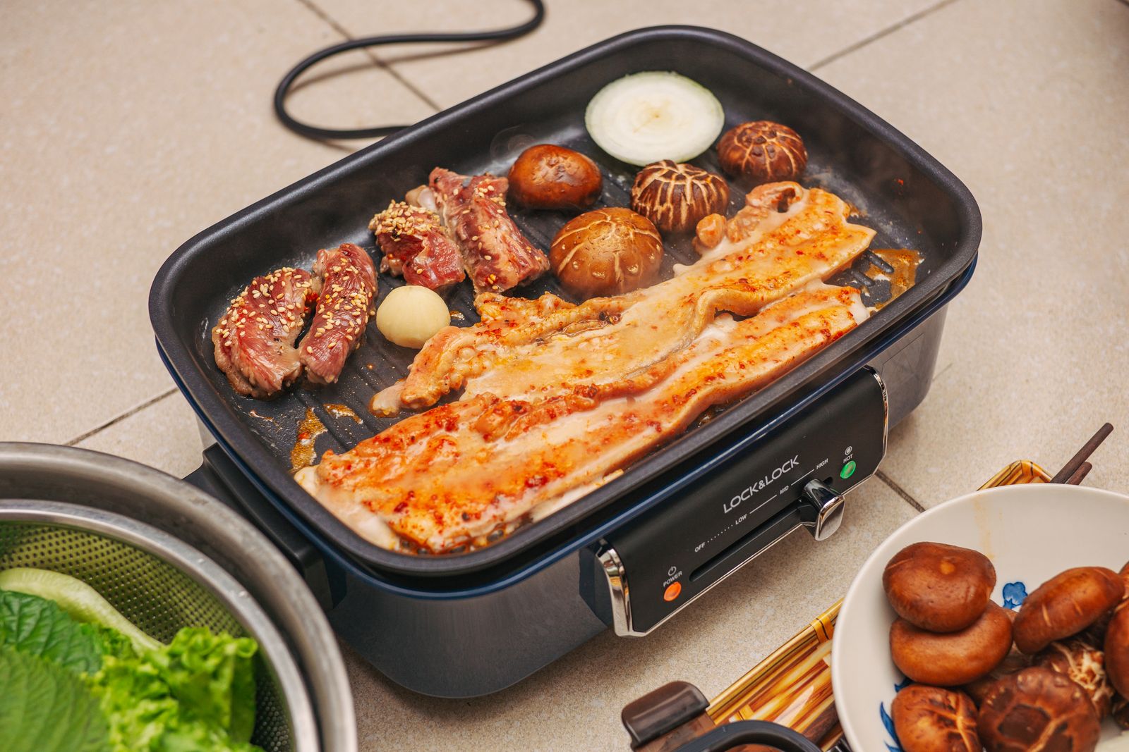 Comida cocinándose en una plancha eléctrica de mesa