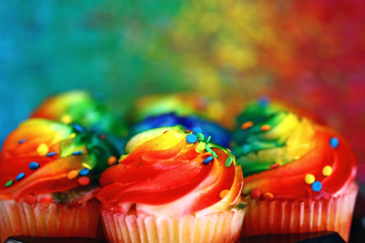 Vibrant cupcakes with rainbow icing and sprinkles, a sweet treat.