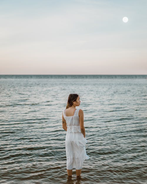 Free Woman in White Dress Standing on Seaside Stock Photo