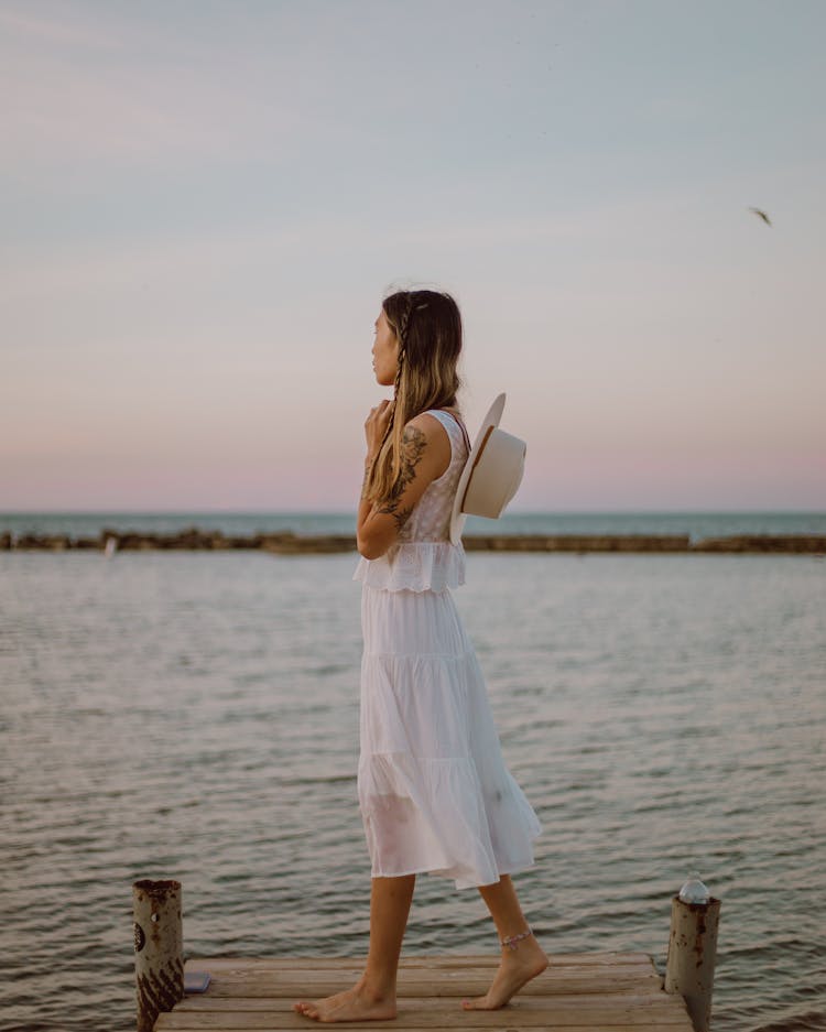 A Woman Standing On A Dock