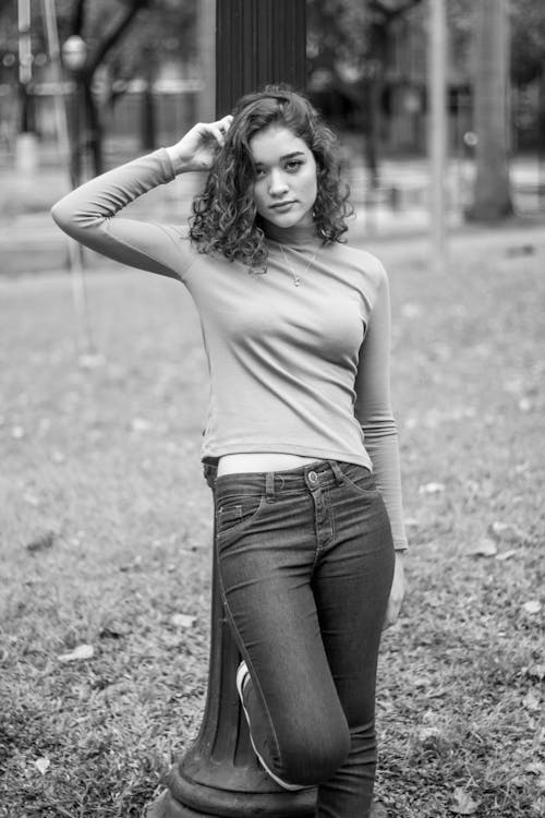 Woman Wearing Long Sleeves Shirt Leaning on Black Post