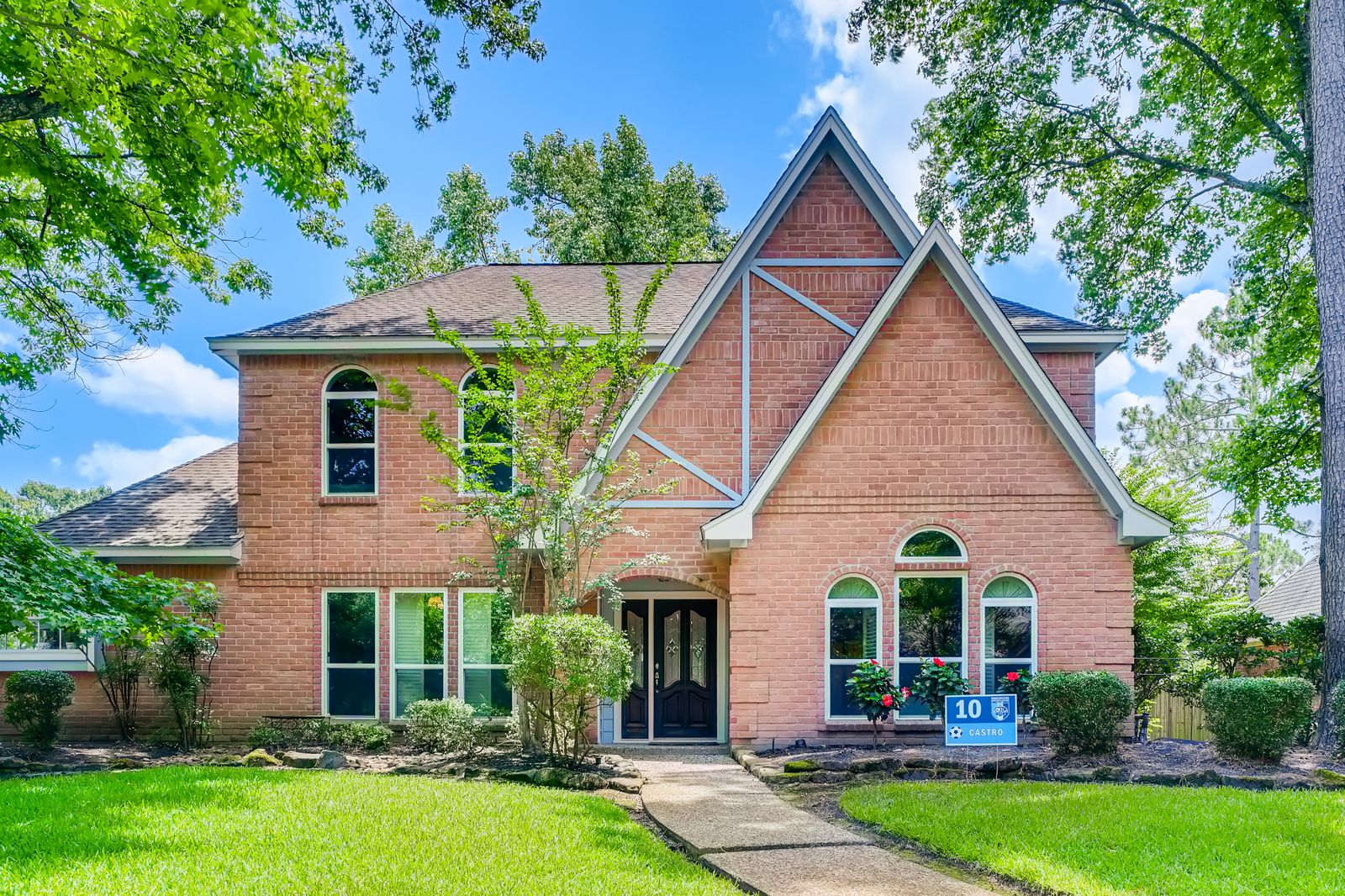 Substantial two-story brick home with a steeply gabled roofline, arched windows, and mature trees on a large lawn, Breckenridge Estates, Naperville IL