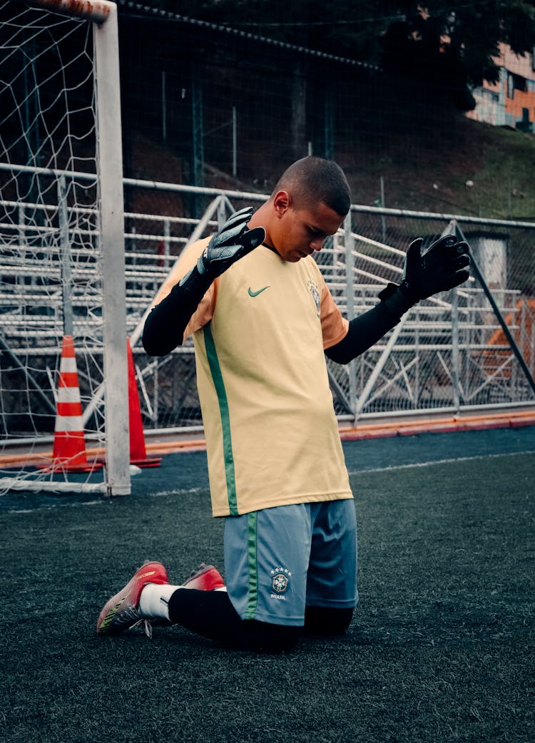 A Football Goalie Kneeling On The Field