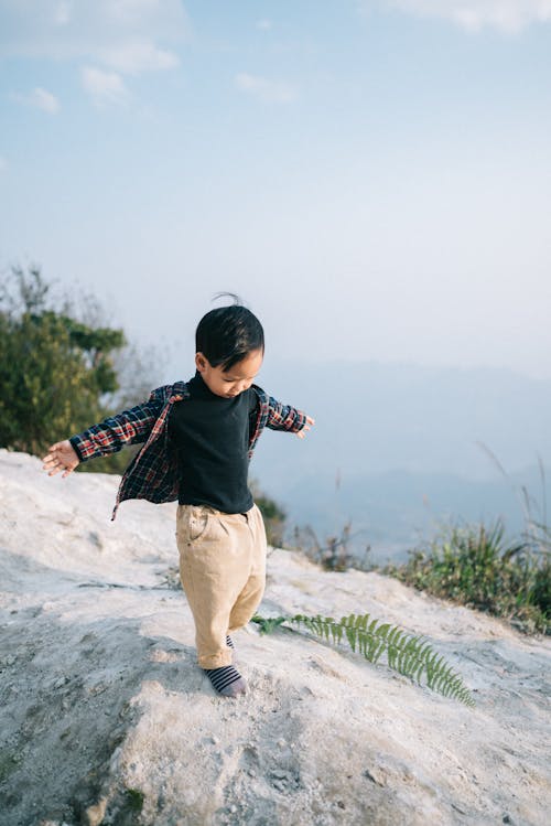 A Boy Standing on a Rock