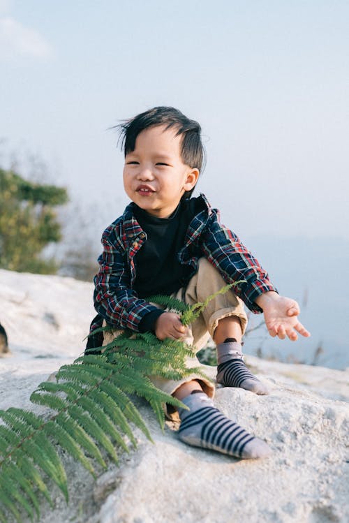 A Child Holding a Fern Leaf