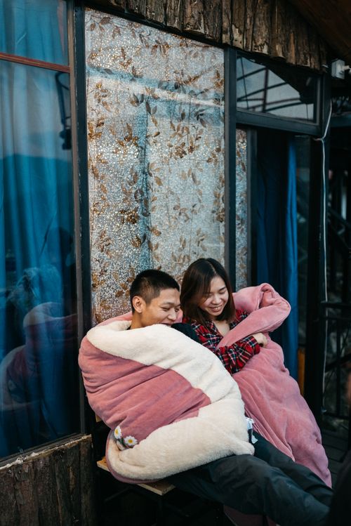 Free A happy couple wrapped in blankets, sharing a cozy moment outdoors. Stock Photo