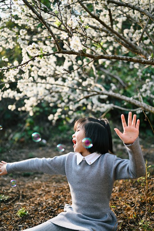 A Girl Playing with Soap Bubbles