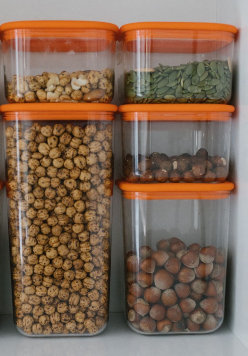 Neatly arranged containers filled with assorted nuts, seeds, and grains