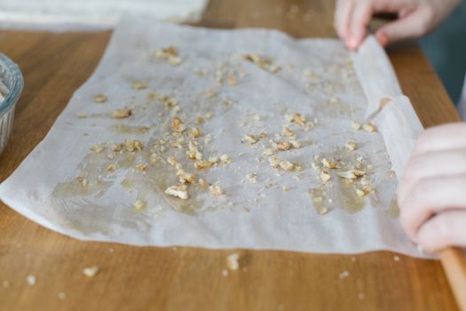 Hands preparing traditional Turkish baklava with filo dough and nuts in Istanbul.