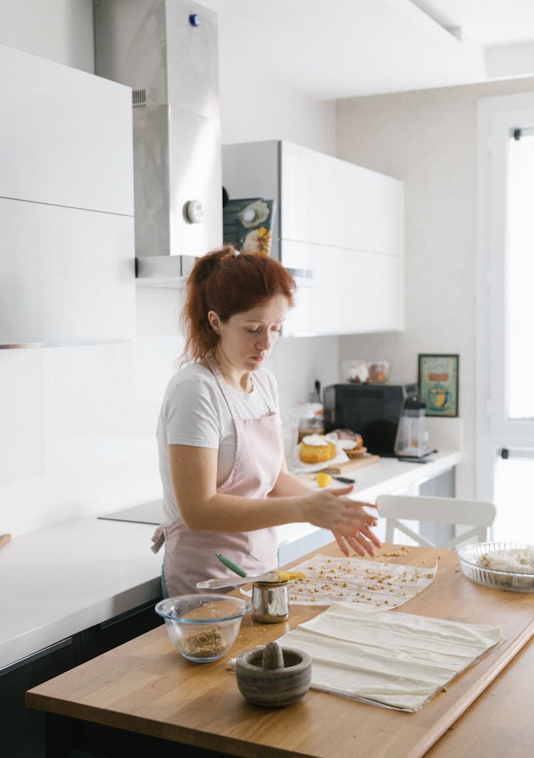 A Woman Preparing Food In A Kitchen