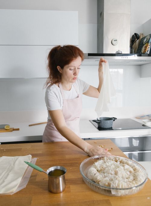 Free A woman with red hair prepares dough in a modern Istanbul kitchen. Stock Photo
