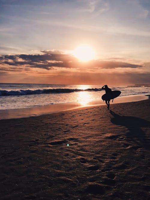 A Surfer Walking on a Beach