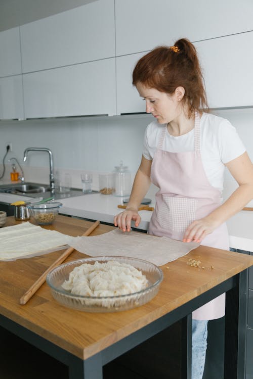A Woman Wearing an Apron while in the Kitchen