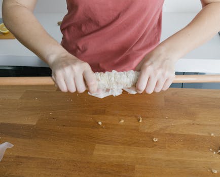 Close-up of hands preparing traditional Turkish food on a kitchen counter.