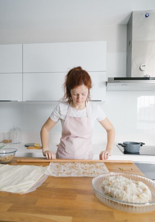 Free Woman makes traditional baklava in a modern Istanbul kitchen, showcasing culinary skills and Turkish culture. Stock Photo