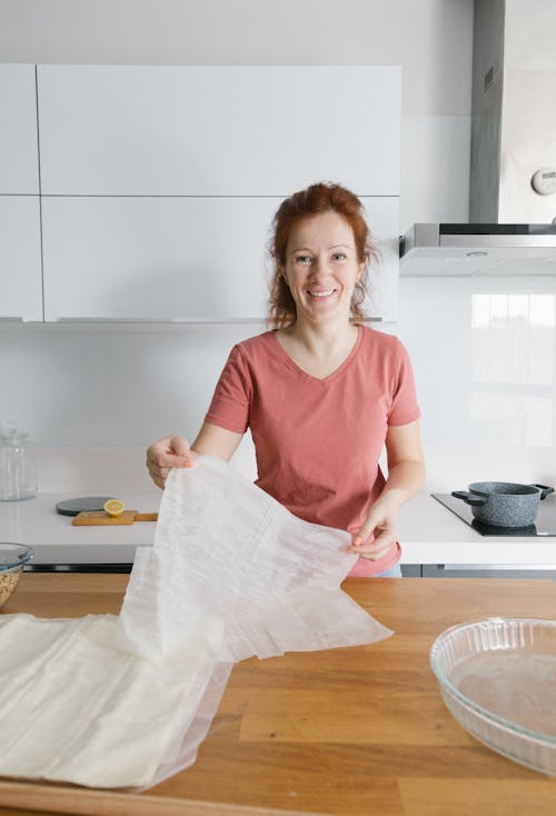 A Woman Smiling while Holding a Cheesecloth