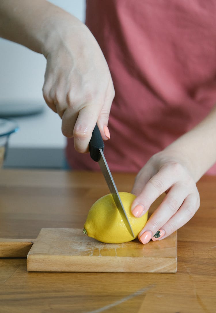 A Person Slicing A Lemon