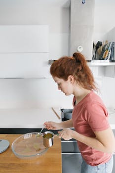 Woman preparing food in a modern Istanbul kitchen, focused and engaged in the process.