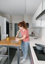 A Woman Holding a Mortar and Pestle on a Wooden Table