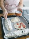 Person Slicing White Food on Black Tray