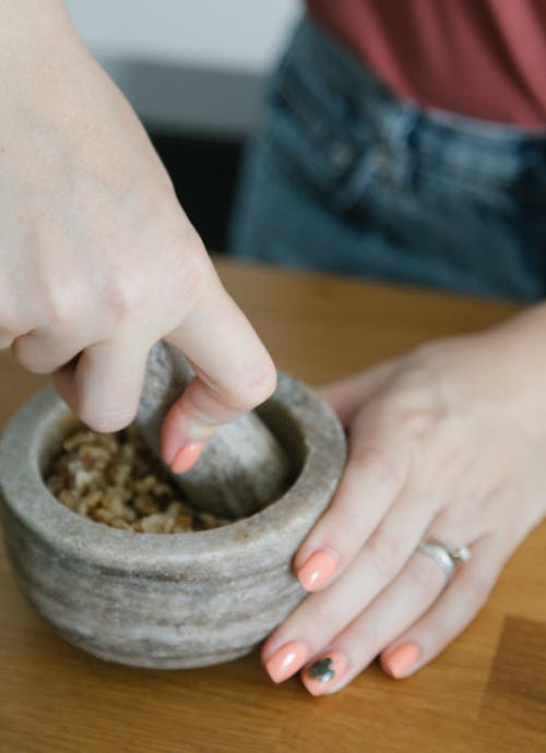 Photo of a Person's Hands Crushing Nuts