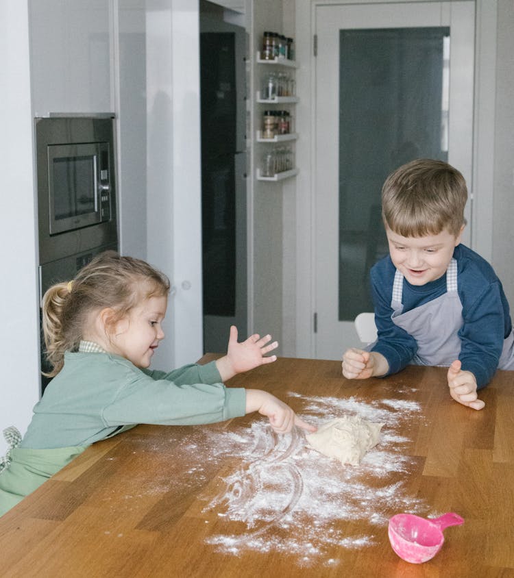 Kids Playing Flour On The Kitchen