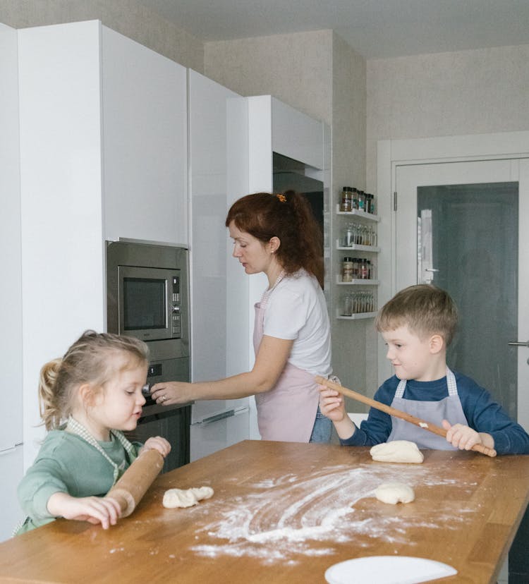 Kids Playing On The Kitchen While Their Mother Is Baking