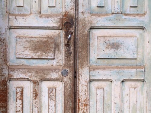 Free Close-up of rustic vintage wooden double doors with antique hardware and textured finish. Stock Photo