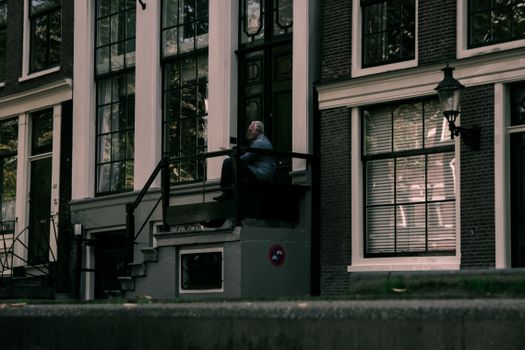 An Elderly Man Sitting on the Building Stoop