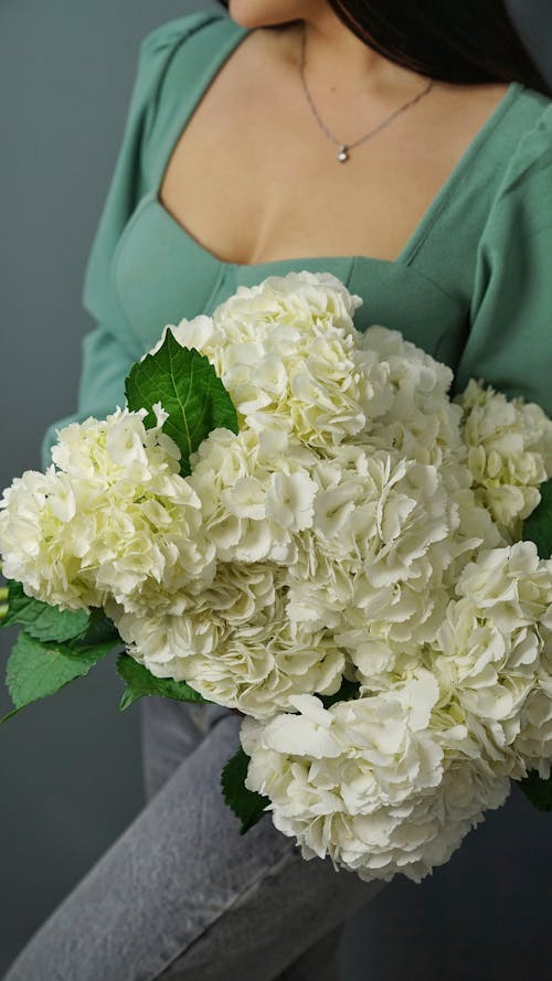 Free A Woman Holding a Bouquet of White Carnation Flowers Stock Photo
