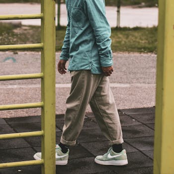Stylish casual outfit featuring a denim shirt and sneakers in an outdoor setting.
