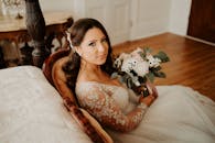 一位穿着蕾丝礼服的美丽新娘在室内婚礼现场拿着花束